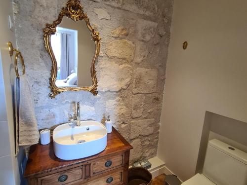 baño con lavabo y espejo en la pared en Gîte Beaulieu-sur-Loire, 6 pièces, 10 personnes - FR-1-590-240, en Beaulieu-sur-Loire