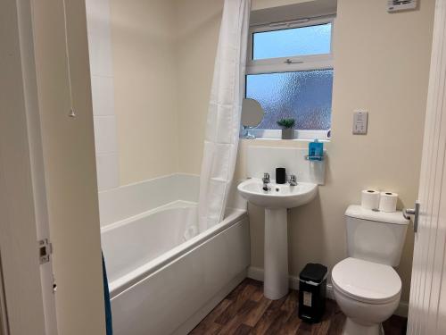 Baño blanco con aseo y lavamanos en SwiftStayUK - 3-Bed fully furnished house near Wolverhampton, Walsall, Cannock - Contractors & Professional workers & Leisure, en Pelsall