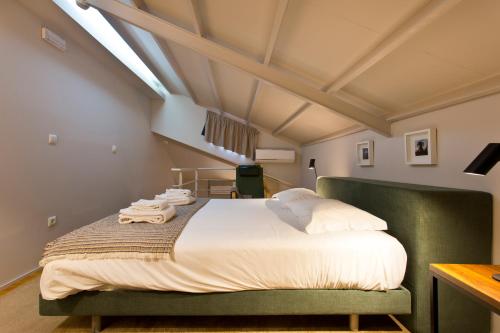 a bedroom with a large bed with a green couch at RVA - Gustave Eiffel Apartments in Porto