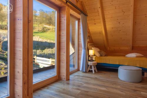 Zimmer mit einem Bett und einem großen Fenster in der Unterkunft Lelu Spa&Natura in Muszyna