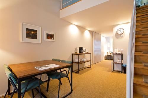 une chambre avec une table, des chaises et une horloge dans l'établissement RVA - Gustave Eiffel Apartments, à Porto