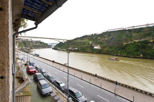 a line of cars parked on a road next to a river at RVA - Gustave Eiffel Apartments in Porto