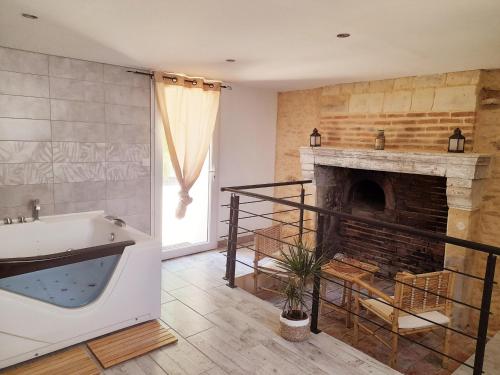 a bathroom with a tub and a fireplace at Gîte Corzé, 4 pièces, 6 personnes - FR-1-622-27 in Corzé