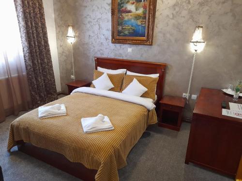 een slaapkamer met een bed met twee handdoeken erop bij Pensiunea Crown Royal in Alba Iulia