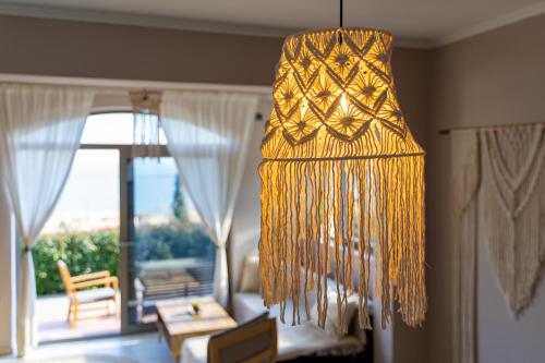 a hanging chandelier with a view of a living room at Driftwood Holiday Home in Argasi