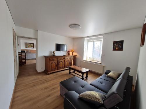 un salon avec un canapé et une télévision dans l'établissement Gîte chaleureux sur une ferme en activité près de Nancy, idéal balades et proche commerces - FR-1-584-181, à Franconville