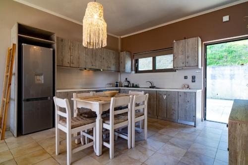 a kitchen with a table and chairs and a chandelier at Driftwood Holiday Home in Argasi