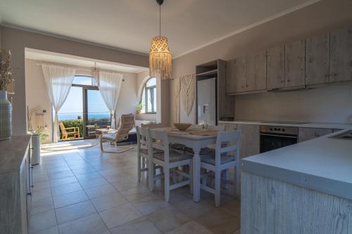 a kitchen with a table and chairs and a dining room at Driftwood Holiday Home in Argassi