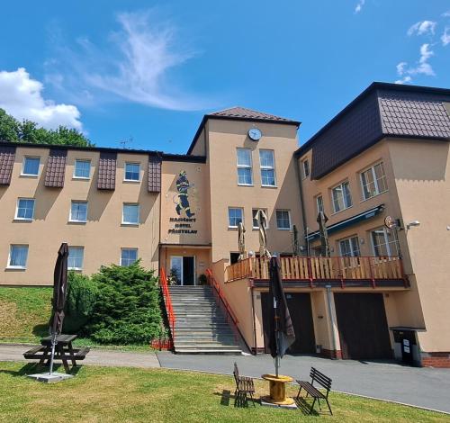a large building with a staircase in front of it at Hasičský hotel Přibyslav in Přibyslav