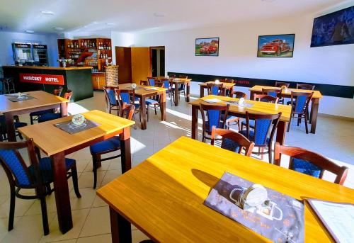Hasičský hotel Přibyslav في Přibyslav: غرفة طعام مع طاولات وكراسي خشبية