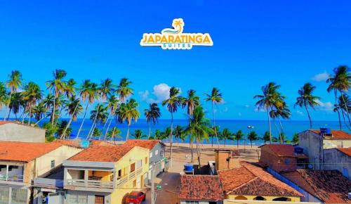 a view of a city with palm trees and the ocean at Japaratinga Suites in Japaratinga