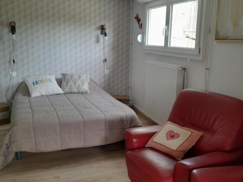1 dormitorio con 1 cama y 1 silla roja en Gîte Vilosnes-Haraumont, 2 pièces, 2 personnes - FR-1-585-81, 