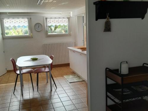 - une cuisine avec une table, une petite table et des chaises dans l'établissement Gîte loft au bord de la Meuse avec jardin, terrasses et activités variées à Vilosnes-Haraumont - FR-1-585-81, à Vilosnes-sur-Meuse