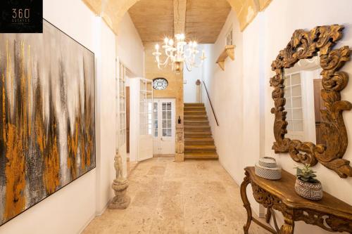 un couloir avec un grand miroir et une table dans l'établissement Palazzo EL Cattedrale in historic MDINA by 360 Estates, à Mdina