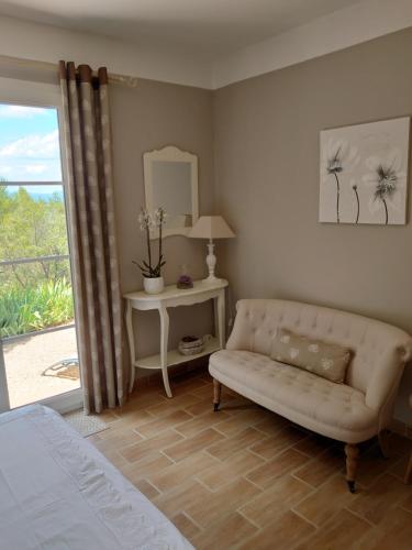 - un salon avec un canapé, une table et une fenêtre dans l'établissement B&B La Boissière Et Le Vialat, à Montagnac