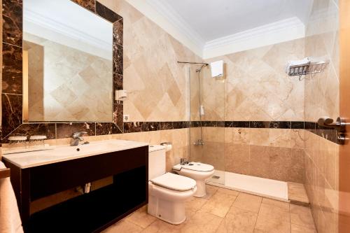 a bathroom with a toilet and a sink and a mirror at Kn Aparthotel Panorámica in Adeje