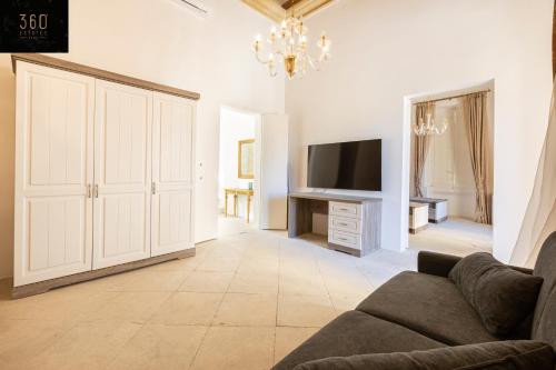 a living room with a couch and a tv at Palazzo EL Cattedrale in historic MDINA by 360 Estates in Mdina