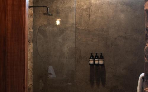 a bathroom with three bottles of wine in a shower at Naakary Home in San Miguel de Allende