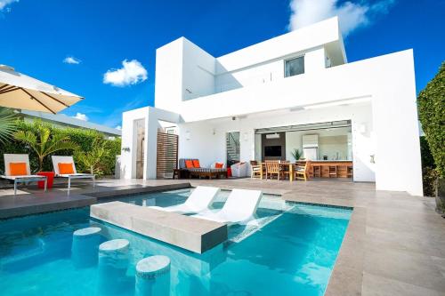 a villa with a swimming pool in front of a house at Oceanside 2 Bedroom Luxury Villa with Private Pool, 500ft from Long Bay Beach -V3 in Providenciales