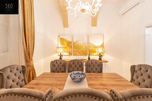 a dining room with a wooden table and chairs at Palazzo EL Cattedrale in historic MDINA by 360 Estates in Mdina