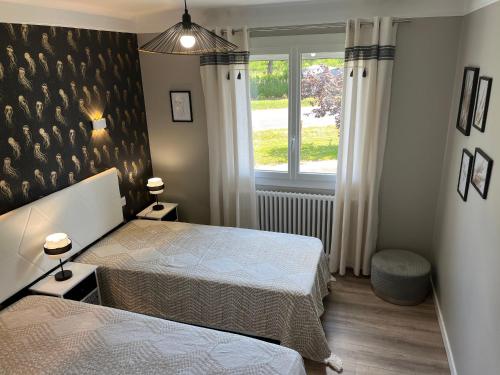 una camera da letto con due letti e una finestra di Maison contemporaine rénovée avec étang privé et terrasse, proche plage - 3 chambres, wifi inclus - FR-1-426-517 a Nieul-le-Dolent