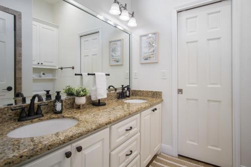a bathroom with two sinks and a large mirror at Beach Front Cottage with Beautiful Ocean Views! in Bolivar Peninsula