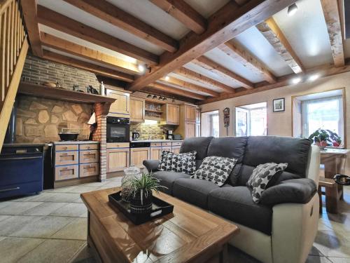un salon avec un canapé et une cuisine dans l'établissement Gîte paisible rénové à St Just, terrasse privée, randonnées, proche Puy en Velay - FR-1-582-343, à Saint-Just-près-Brioude