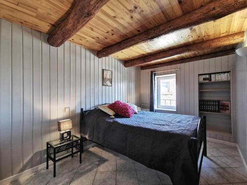 ein Schlafzimmer mit einem Bett und einer Holzdecke in der Unterkunft Gîte Saint-Just-prés-Brioude, 3 pièces, 4 personnes - FR-1-582-343 in Saint-Just-près-Brioude