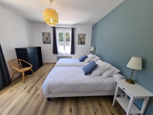 a bedroom with two beds and a table and a chair at Gîte en Sologne au calme avec étang, proche d'Orléans et châteaux, idéal randonnées et pêche - FR-1-590-242 in Vannes-sur-Cosson