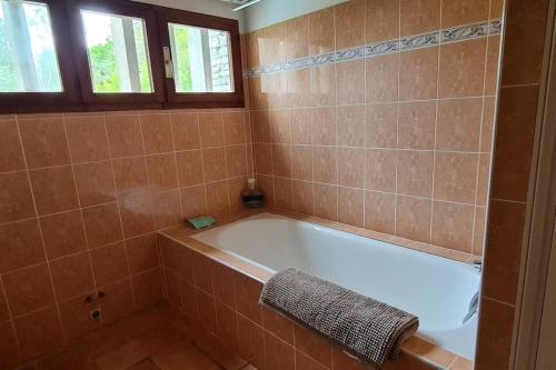 uma casa de banho com banheira num quarto em azulejo em La Bergerie La Belle Epoque, piscine et plage em Saint-Florent