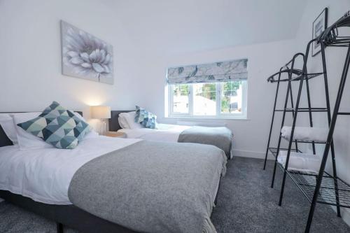 Un dormitorio con 2 camas y una escalera. en Perfect for Contractors with on site parking en Brettell Lane