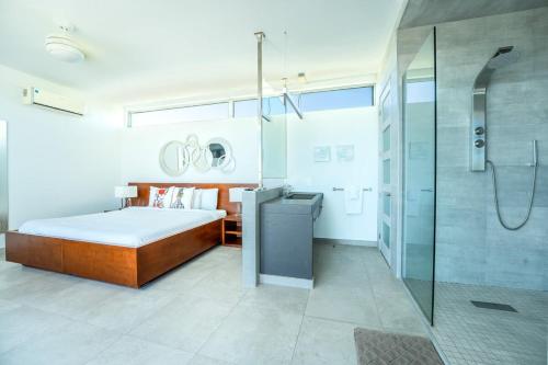 a bedroom with a bed and a glass shower at Oceanside 3 Bedroom Luxury Villa with Private Pool, 500ft from Long Bay Beach -V2 in Providenciales