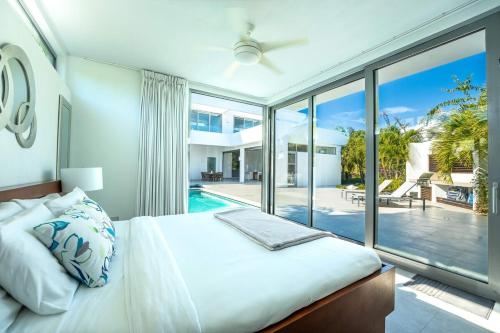 - une chambre avec un grand lit et une grande fenêtre dans l'établissement Oceanside 3 Bedroom Luxury Villa with Private Pool, 500ft from Long Bay Beach -V2, à Providenciales