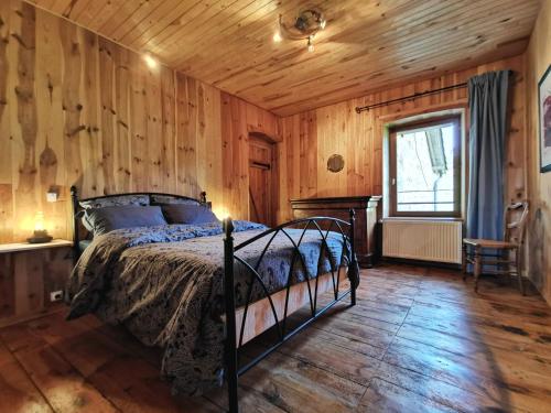 - une chambre avec un lit et un mur en bois dans l'établissement Gîte Craponne-sur-Arzon, 6 pièces, 10 personnes - FR-1-582-346, à Craponne-sur-Arzon