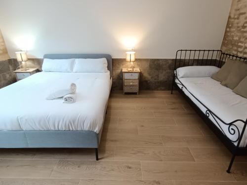 1 dormitorio con 2 camas y un pájaro sentado en la cama en Almona Puente de Barcas - Kainga Homes, en Sevilla