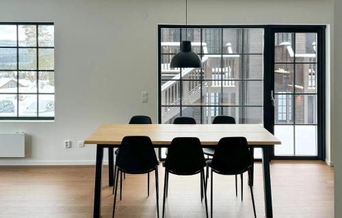 comedor con mesa de madera y sillas negras en Stunning Apartment In Idre With Sauna, en Idre