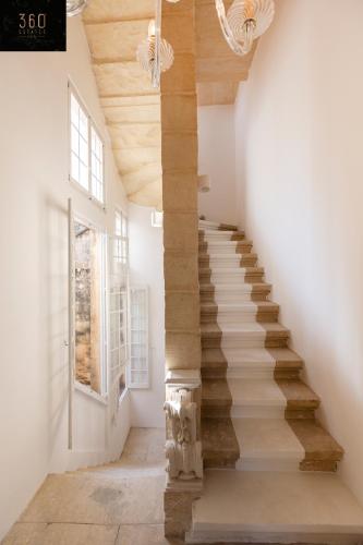 a staircase in a house with a wooden ceiling at Palazzo EL Cattedrale in historic MDINA by 360 Estates in Mdina
