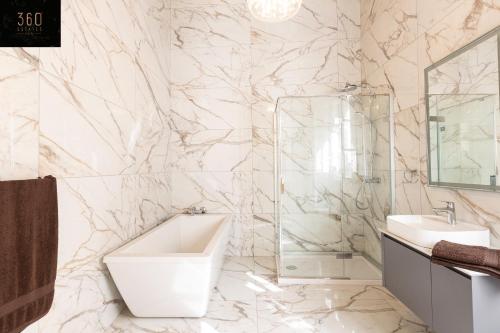 a bathroom with a white tub and a sink at Palazzo EL Cattedrale in historic MDINA by 360 Estates in Mdina