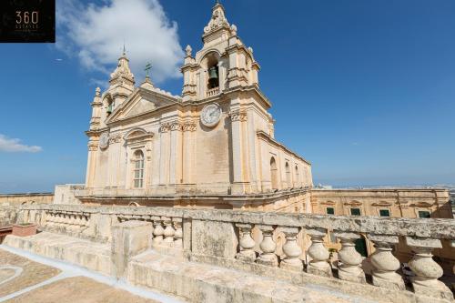 a building with a clock tower on top of it at Palazzo EL Cattedrale in historic MDINA by 360 Estates in Mdina