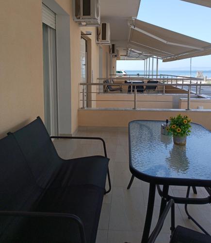 a room with a table and chairs and a balcony at Navarino Luxe Suites in Perea