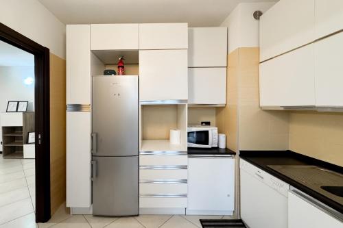 a kitchen with white cabinets and a refrigerator at 5min RhoFiera~10minMetro~Parking in Pero