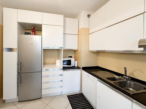 a kitchen with white cabinets and a stainless steel refrigerator at 5min RhoFiera-10minMetro-Parking in Pero