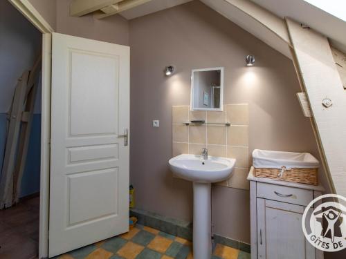 La salle de bains est pourvue d'un lavabo et d'une porte blanche. dans l'établissement Charmant Gîte en Bord de Loire avec Jardin, Proche de Saumur et des Châteaux - FR-1-622-39, à Saint-Martin-de-la-Place