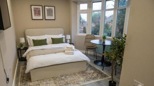 a bedroom with a bed and a table and a window at Private double bedroom with bathroom and amenities in Harrow