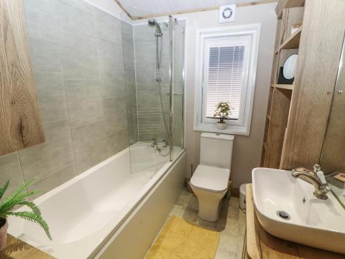 a bathroom with a tub and a toilet and a sink at Gressingham 7 in Carnforth