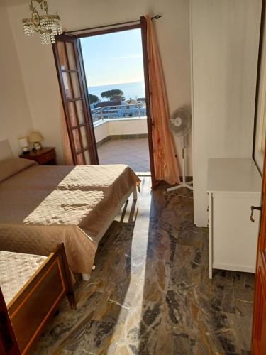 um quarto com 2 camas e uma porta para uma varanda em Villa Greco em Cirella