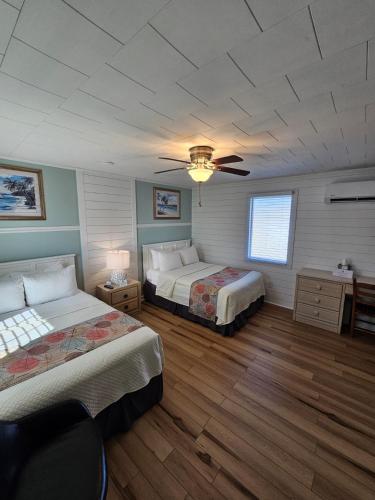 a bedroom with two beds and a ceiling fan at Island Guesthouse and Motel OBX in Manteo