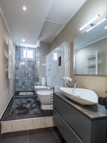 a bathroom with two toilets and a sink and a shower at Europa APT - Dolcevita Holiday in Florence