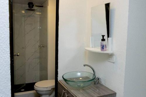 y baño con lavabo de cristal y aseo. en Apartamento cerca centro bogota, en Bogotá