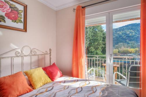 um quarto com uma cama e uma grande janela em Casa Rural Nacimiento 1 em Benaoján